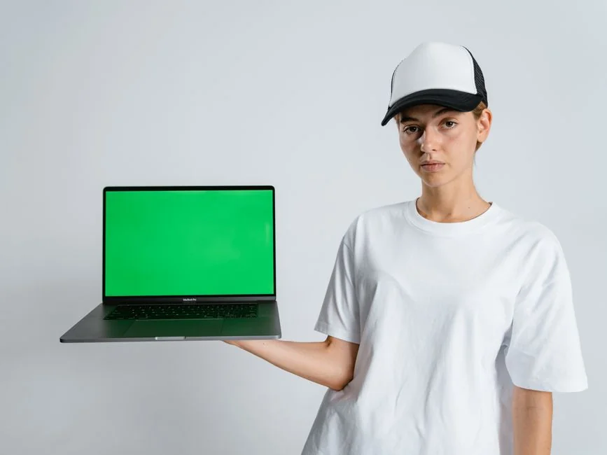 Un smartphone dans un mini-chariot sur un ordinateur portable symbolise les achats en ligne et le paiement numérique.